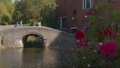 Panning-Shot-of-People-Walking-Over-a-Canal-Bridge-In-Birmingham-