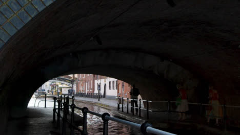 Kamerafahrt-Von-Menschen,-Die-Durch-Einen-Tunnel-Am-Kanal-Gehen