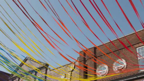 Low-Angle-Panning-Shot-of-Decorative-Ribbons-Tied-to-Building