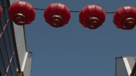 Low-Angle-Tracking-Shot-of-Chinese-Lanterns-Hanging-from-Buildings