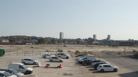 Tilting-Shot-of-Cars-Parked-In-Front-of-Desolate-Construcción-Site