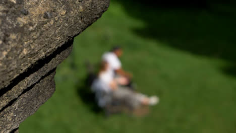 Defocused-Shot-of-Two-People-Sat-On-Public-Park-Bench-In-Oxford-