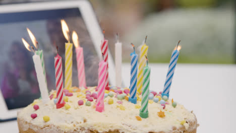 Kerzen-Werden-Auf-Geburtstagstorte-Ausgeblasen,-Während-Großeltern-Per-Videoanruf-Zuschauen