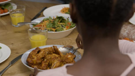 Young-Girl-Plating-Up-Some-Chicken-Onto-Plate-During-Dinner