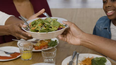 Woman-Passing-Bowl-of-Salad-to-Man-at-Family-Dinner-