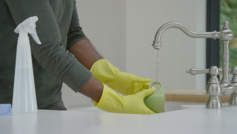 Man-Cleaning-Mug-Under-Running-Water-from-Kitchen-Tap-
