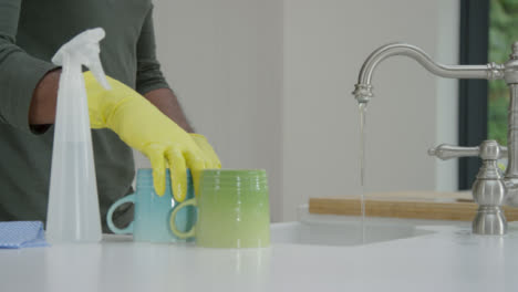 Man-Cleaning-a-Mug-Under-Running-Water-from-Kitchen-Tap-