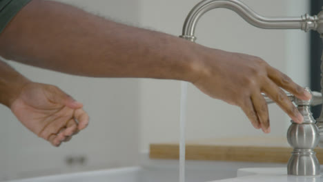 Man-Cleaning-His-Hands-with-Soapy-Water-Under-Running-Tap