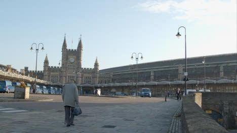 Wide-Shot-of-Senior-Man-Walking-In-Front-of-Bristol-Temple-Meads-Station