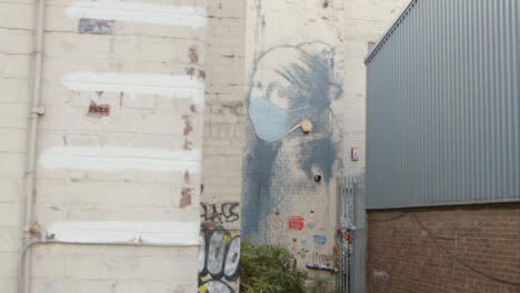 Sliding-Shot-Revealing-Banksy-Girl-Wearing-Pearl-Earrings-Artwork-In-Bristol-England