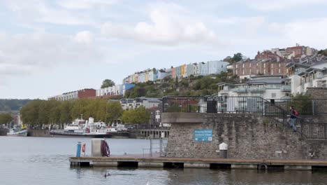 Wide-Shot-of-Young-Man-Walking-Up-Steps-at-Bristol-Harbour-In-Bristol-England