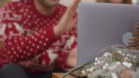 Extreme-Nahaufnahme-Von-Weihnachtlichen-Tischdekorationen-Vor-Dem-Paar-Mit-Laptop