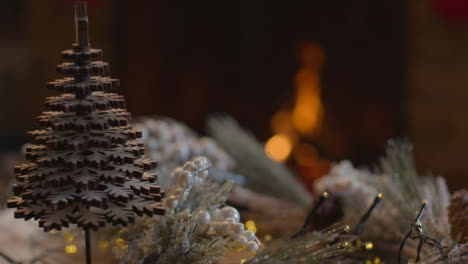 Extreme-Close-Up-Shot-of-Table-Christmas-Decorations-In-Front-of-Cosy-Fire