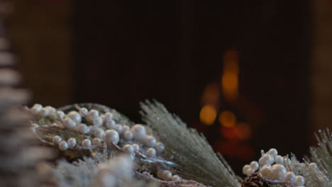 Extreme-Close-Up-Shot-of-Table-Christmas-Ornaments-In-Front-of-Cosy-Fireplace