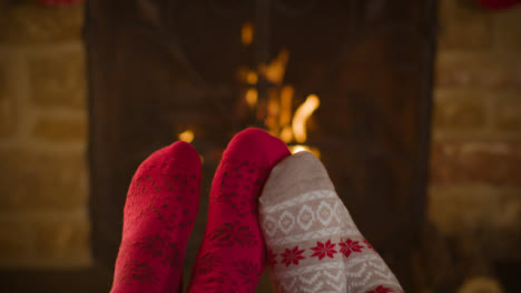 Close-Up-Shot-of-Couples-Feet-In-Front-of-a-Burning-Fireplace