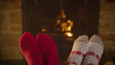 Close-Up-Shot-of-Couples-Feet-In-Front-of-a-Cosy-Burning-Fireplace