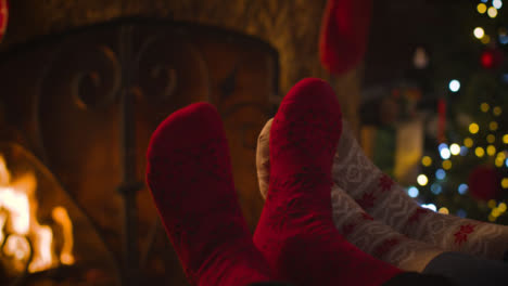 Close-Up-Shot-of-Couples-Feet-In-Front-of-Cosy-Burning-Fireplace