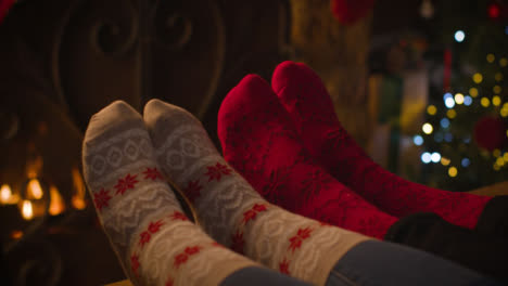 Close-Up-Shot-of-Couples-Feet-In-Front-of-a-Cosy-Burning-Fire