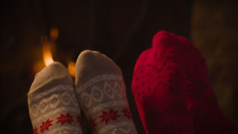 Extreme-Close-Up-Shot-of-Couples-Feet-In-Front-of-Burning-Fireplace