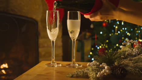 Sliding-Close-Up-Shot-of-Female-Hands-Pouring-Two-Glasses-of-Champagne-From-Bottle