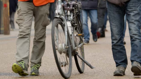 Medium-Shot-of-Cyclist-Walking-Bike-On-Busy-Street-In-Oxford-England
