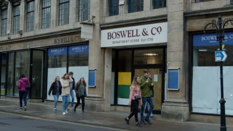 Sliding-Shot-of-People-Walking-Past-Closed-Down-Boswells-Department-Store-In-Oxford-England