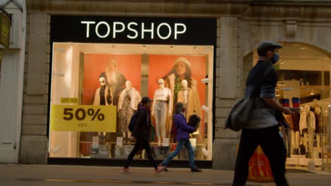 Low-Angle-Shot-of-People-Walking-Past-TopShop-Store-In-Oxford-England