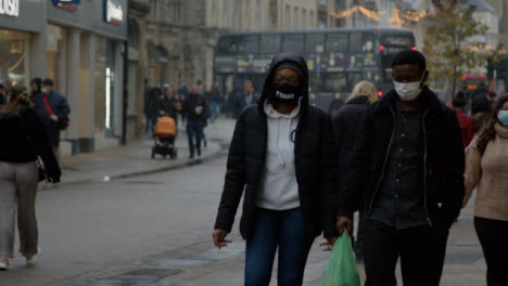 Lange-Aufnahme-Von-Menschen-Mit-Gesichtsmasken,-Die-Eine-Belebte-Straße-In-Oxford-England-Entlang-Gehen