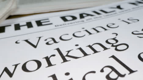 Schieben-Sie-Extreme-Nahaufnahmen-Der-Titelseiten-Von-Zeitungen-Mit-Covid-19-Impfstoff-Schlagzeilen-Close