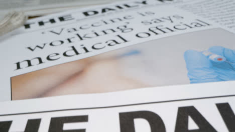 Schieben-Sie-Die-Titelseiten-Einiger-Zeitungen-Mit-Covid-19-Impfstoff-Schlagzeilen-In-Extremer-Nahaufnahme