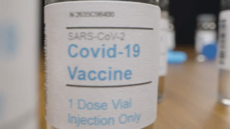Schieben-Sie-Nahaufnahme-An-Spritzen-Und-Fläschchen-Mit-Coronavirus-Impfstoff-Vorbei