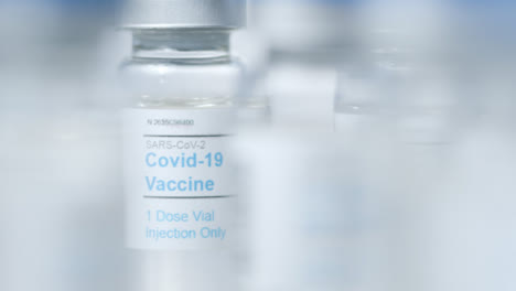 Extreme-Nahaufnahme,-Ziehen-Sie-Den-Fokus-Durch-Mehrere-Fläschchen-Mit-Covid-Impfstoff