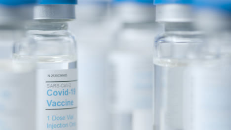 Extreme-Close-Up-Pull-Focus-Shot-Through-Multiple-Vials-of-Covid-19-Vaccine