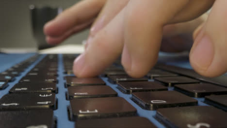 Sliding-Extreme-Close-Up-Shot-of-Pair-of-Male-Hands-Typing-On-a-Laptop-Keyboard