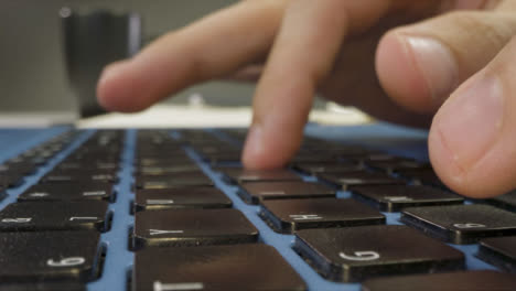 Sliding-Extreme-Close-Up-Shot-of-Male-Hands-Typing-On-a-Laptop-Keyboard