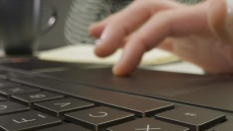 Schieben-Sie-Extreme-Nahaufnahmen-Von-Männlichen-Händen-Mit-Einer-Laptop-Tastatur-Und-Einem-Trackpad