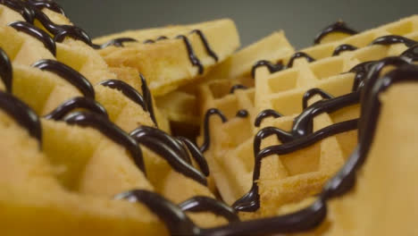 Sliding-Extreme-Close-Up-Shot-of-Chocolate-Sauce-Pouring-Onto-Waffles