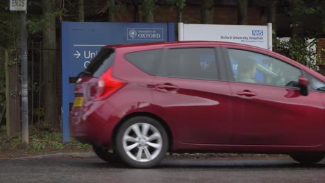 Wide-Shot-of-Cars-and-Pedestrian-Passing-By-Churchill-Hospital-Sign