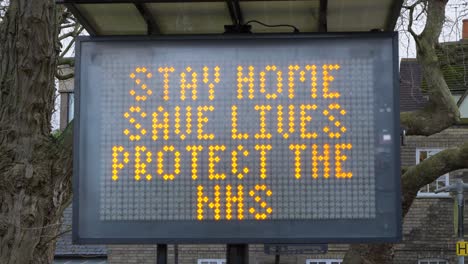 Handheld-Close-Up-Shot-of-Stay-Home-Save-Lives-Roadside-Sign-