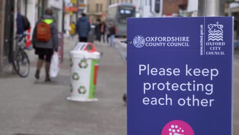 Handheld-Close-Up-Shot-of-COVID-Signage-In-City-Centre-