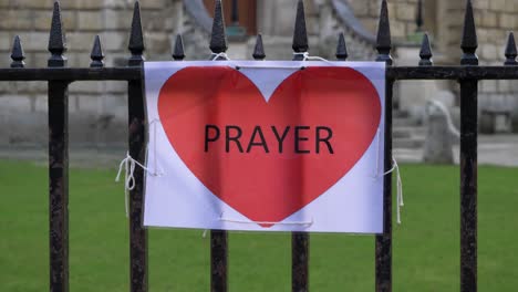 Handheld-Close-Up-Shot-of-A4-Prayer-Sign-Tied-to-a-Railing-