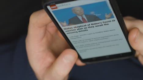 High-Angle-Close-Up-of-Hands-Scrolling-US-Politics-News-Website-On-Smartphone