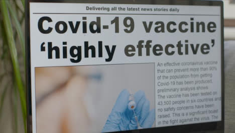 Sliding-Close-Up-of-Coronavirus-Vaccine-News-Article-On-Laptop-