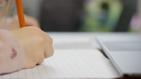 Close-Up-Shot-of-Childs-Hand-Writing-On-Piece-of-Paper