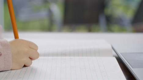 Plano-Medio-De-La-Mano-Del-Niño-Escribiendo-En-Una-Hoja-De-Papel