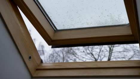 Close-Up-Shot-of-Rainwater-Dripping-from-Open-Skylight-Window