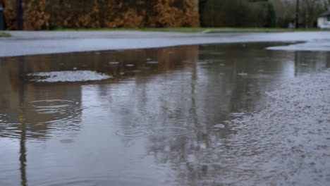 Close-Up-Shot-of-Rain-Droplets-Landing-In-Puddle-