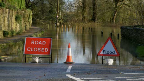 Long-Shot-of-Road-Closed-and-Flood-Signs-In-Front-of-Flooded-Street