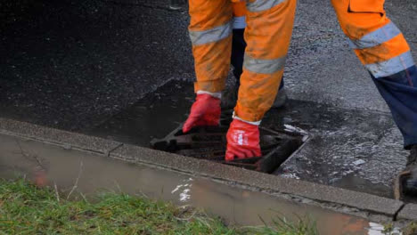 High-Angle-Shot-of-Drainage-Worker-Placing-Down-Storm-Drain-Cover-