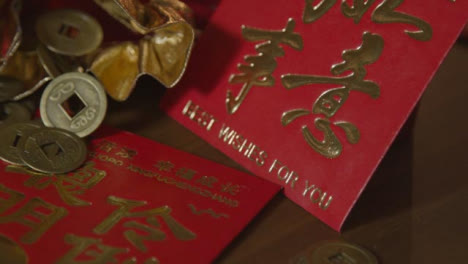 Sliding-Close-Up-Shot-of-Chinese-New-Year-Red-Envelopes-and-Coins